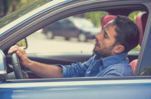 a drowsy man driving a car